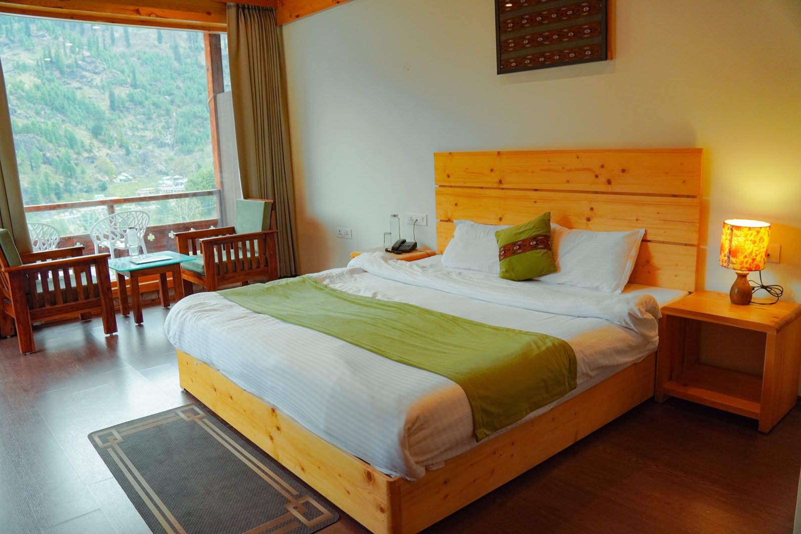 King bed under a pine ceiling, mountains framed in the window