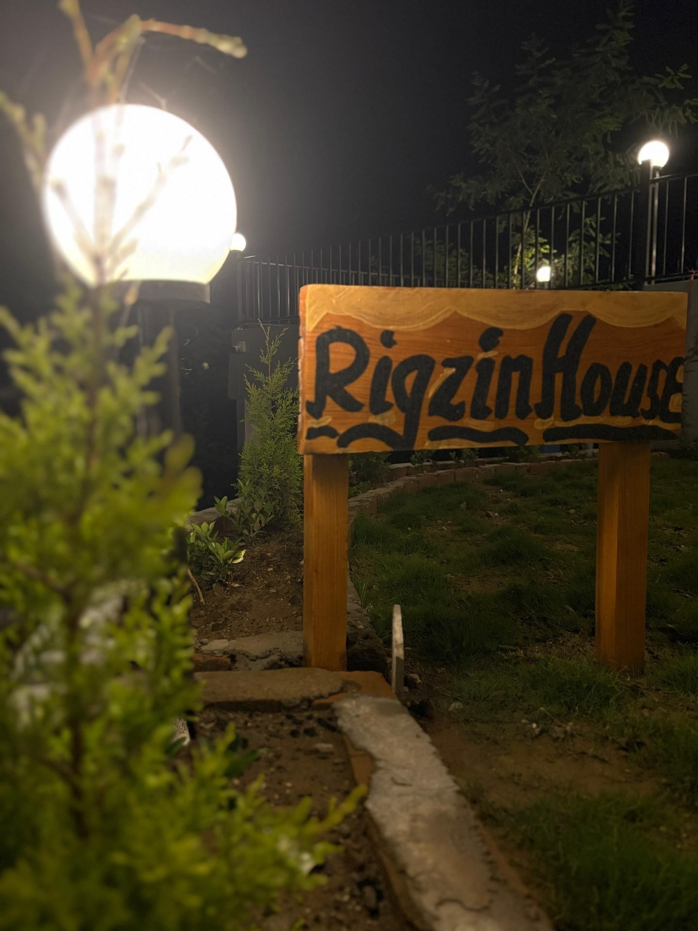 The Rigzin House sign at night